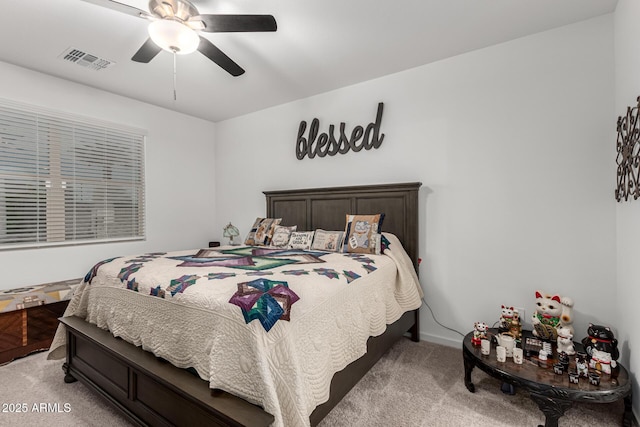 bedroom with visible vents, a ceiling fan, and light colored carpet