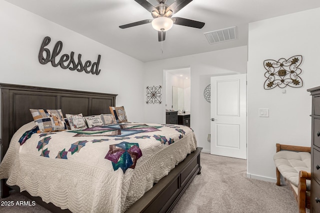 bedroom featuring light carpet, ensuite bath, baseboards, visible vents, and ceiling fan