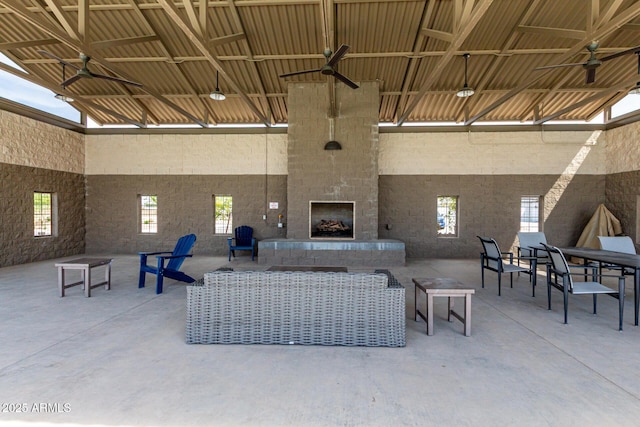 view of patio featuring outdoor dining space, a fireplace, and ceiling fan