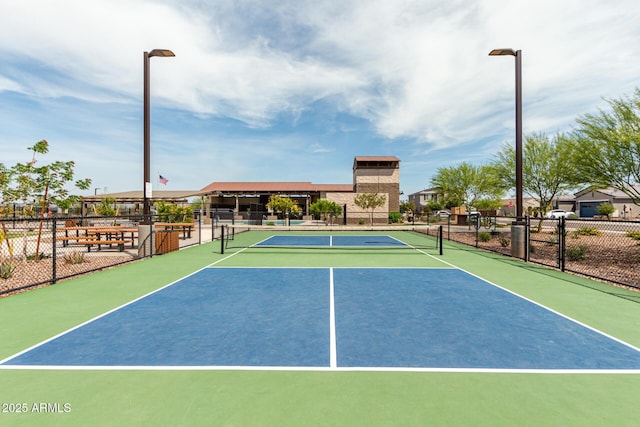 view of tennis court with community basketball court and fence