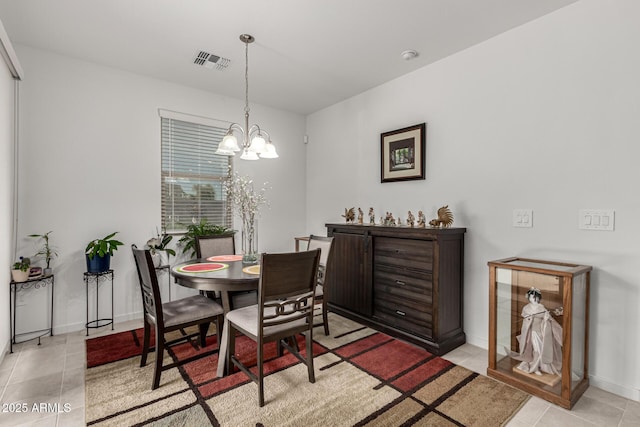 dining area with light tile patterned flooring, baseboards, visible vents, and a notable chandelier