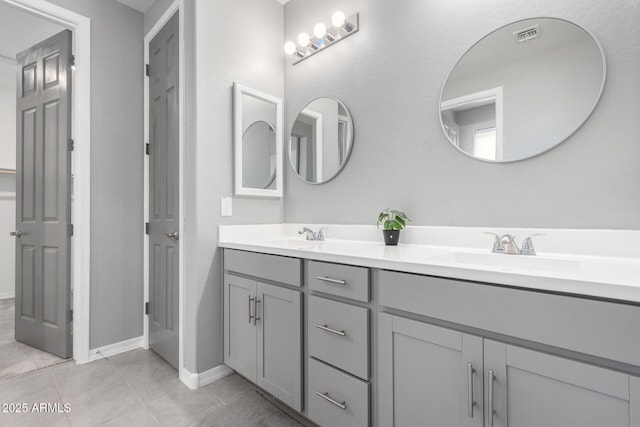 bathroom with double vanity, visible vents, tile patterned floors, and a sink