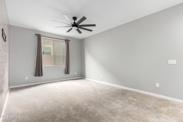 spare room with baseboards, carpet floors, and a ceiling fan