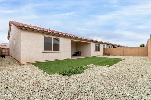 back of house with a patio, a tiled roof, a fenced backyard, and stucco siding