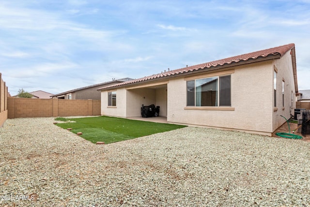 back of property featuring stucco siding, a patio area, a fenced backyard, and a tiled roof