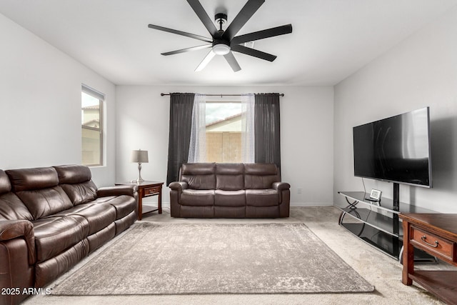 living area featuring carpet, a healthy amount of sunlight, baseboards, and ceiling fan