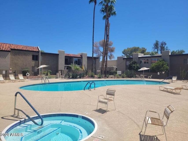 view of swimming pool featuring a patio area and a hot tub