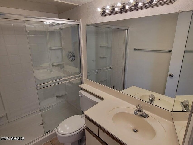 bathroom with an enclosed shower, vanity, and toilet