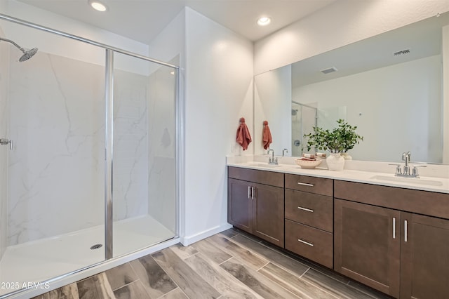 bathroom with vanity and a shower with door