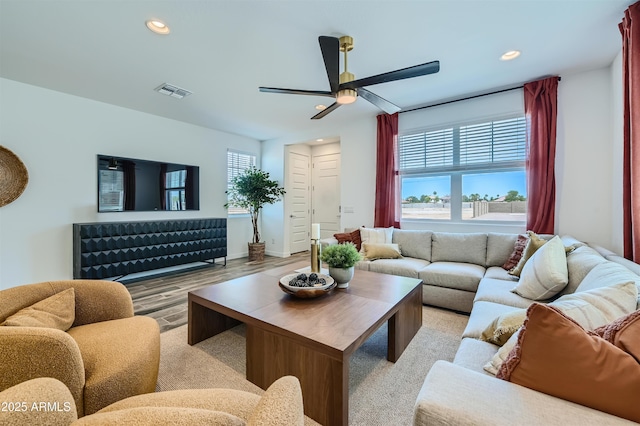 living room featuring ceiling fan, light hardwood / wood-style floors, and a wealth of natural light