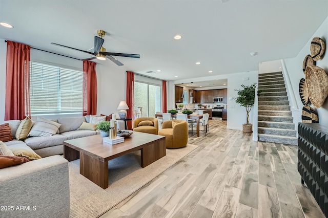 living room with ceiling fan and light wood-type flooring