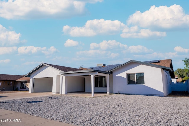 ranch-style home with a patio area and solar panels