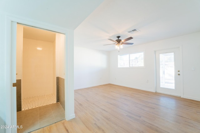 empty room with ceiling fan and light hardwood / wood-style flooring