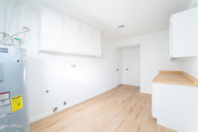 laundry area with hookup for an electric dryer, water heater, cabinets, and light hardwood / wood-style flooring