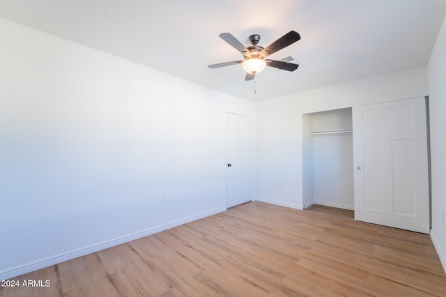 unfurnished bedroom featuring ceiling fan, a closet, and light hardwood / wood-style flooring