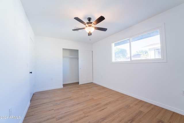 unfurnished bedroom featuring a closet, light wood-type flooring, and ceiling fan