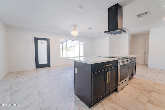 kitchen featuring wall chimney exhaust hood, a center island, light stone counters, and electric range