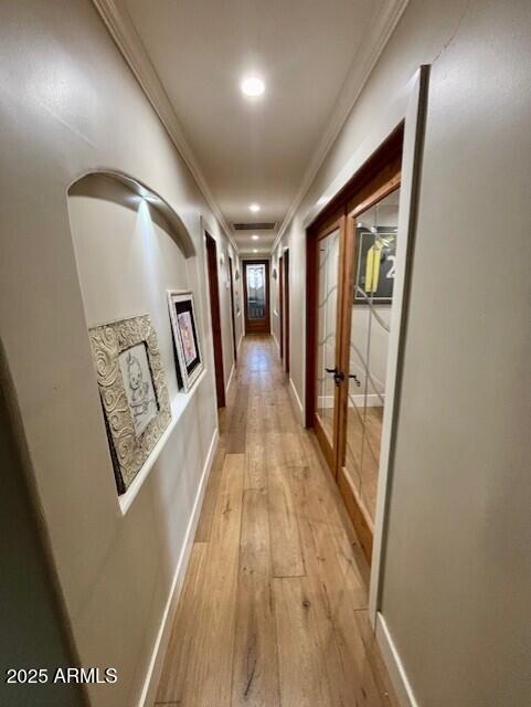 hall with crown molding, light hardwood / wood-style flooring, and french doors