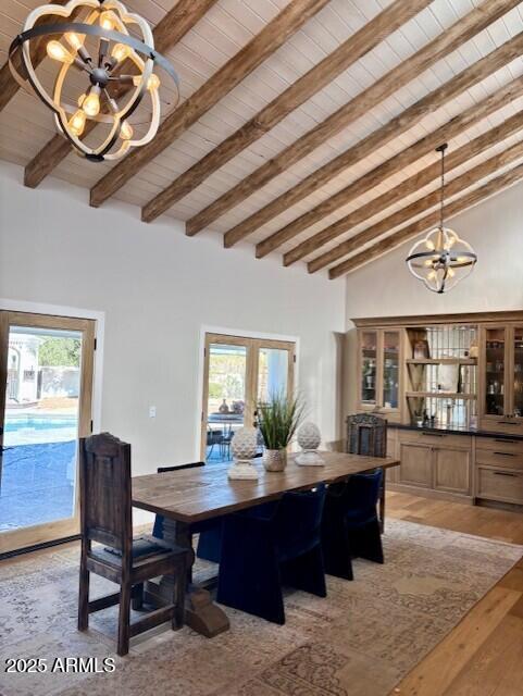 dining room with an inviting chandelier, high vaulted ceiling, light hardwood / wood-style floors, wooden ceiling, and french doors