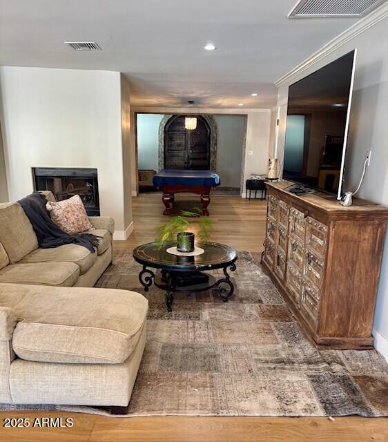 living room with ornamental molding and wood-type flooring