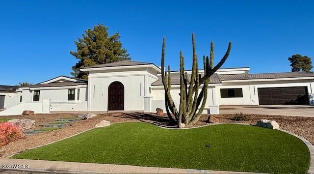 ranch-style home featuring a garage and a front yard