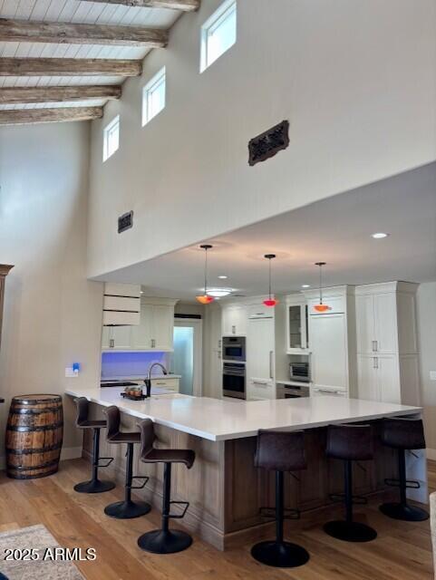 kitchen featuring a large island, hanging light fixtures, and light hardwood / wood-style floors