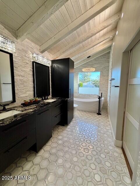 bathroom with vanity, vaulted ceiling with beams, wood ceiling, and tiled bath