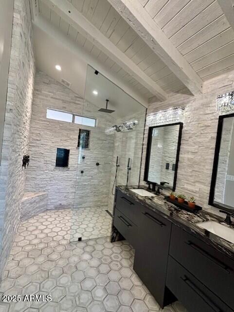 bathroom featuring tiled shower, vanity, and lofted ceiling with beams