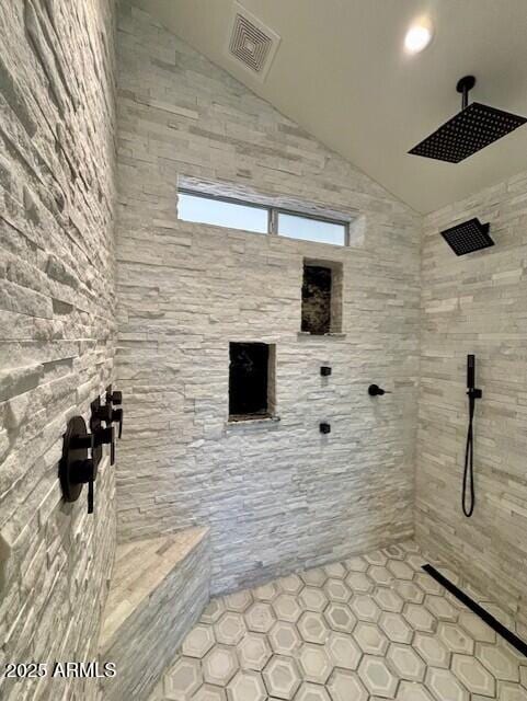 bathroom featuring lofted ceiling and a shower