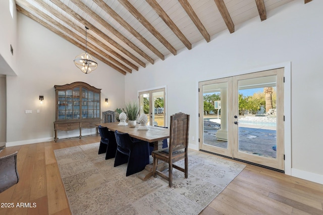 dining area featuring light hardwood / wood-style flooring, wooden ceiling, beam ceiling, and french doors