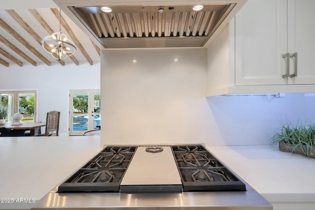 kitchen featuring premium range hood, hanging light fixtures, beam ceiling, white cabinets, and french doors