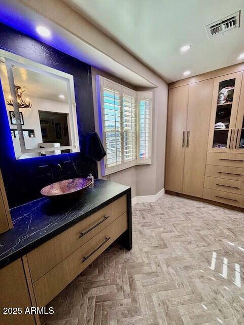 bathroom featuring parquet flooring and vanity