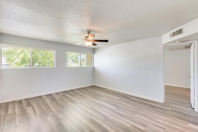 spare room featuring light hardwood / wood-style flooring, ceiling fan, and a textured ceiling