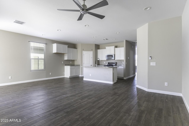 unfurnished living room with dark hardwood / wood-style floors, sink, and ceiling fan