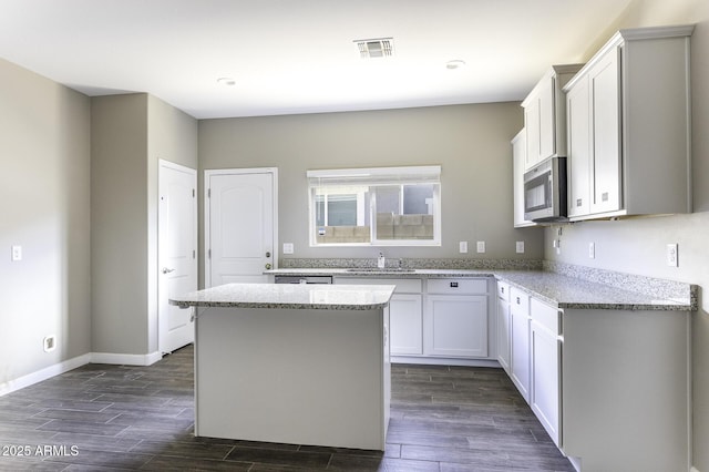 kitchen featuring sink, white cabinetry, light stone counters, dark hardwood / wood-style flooring, and a kitchen island