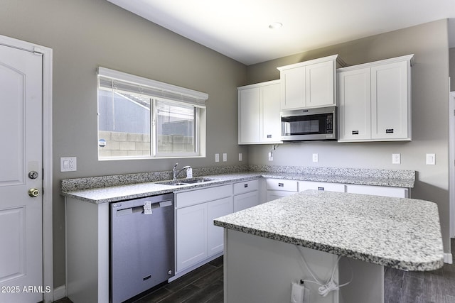 kitchen featuring sink, dark hardwood / wood-style flooring, a kitchen island, stainless steel appliances, and white cabinets