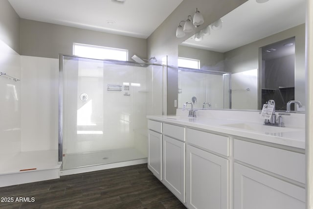 bathroom with a shower with door, vanity, and hardwood / wood-style floors