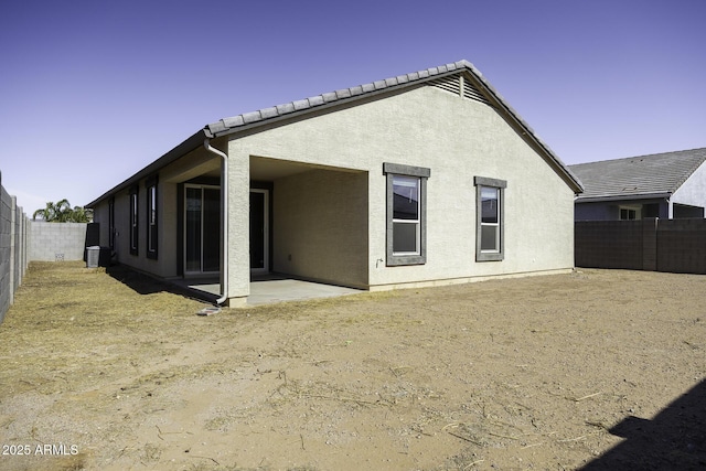 rear view of property featuring a patio and central AC