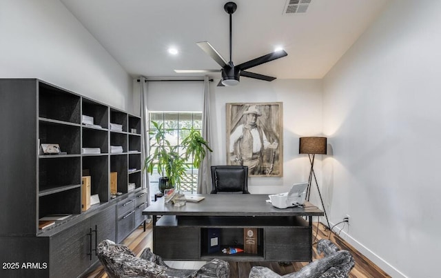 office featuring baseboards, visible vents, a ceiling fan, and wood finished floors