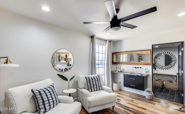 living area with a ceiling fan, recessed lighting, and wood finished floors