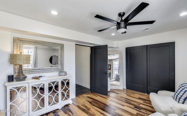 living area with recessed lighting, visible vents, a ceiling fan, wood finished floors, and baseboards