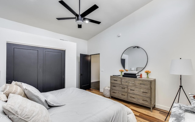 bedroom with high vaulted ceiling, wood finished floors, a ceiling fan, and baseboards