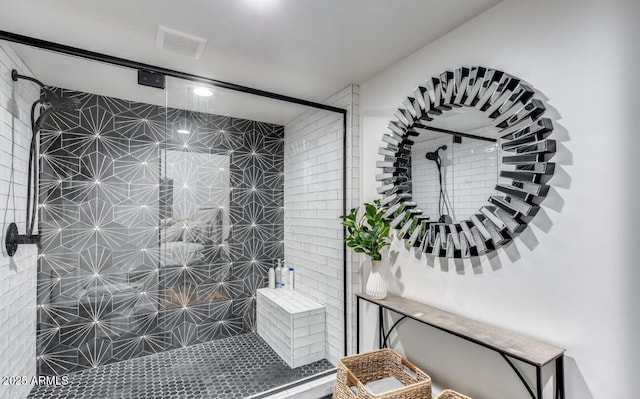 bathroom featuring tiled shower and visible vents