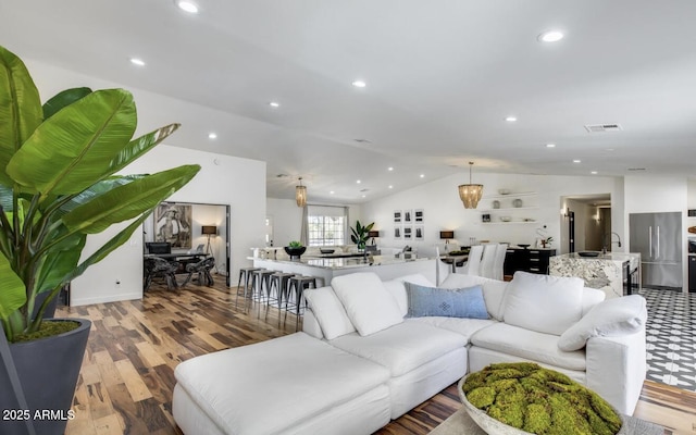 living room with recessed lighting, visible vents, vaulted ceiling, and wood finished floors