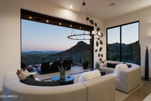 living room with a mountain view, a chandelier, and light hardwood / wood-style flooring