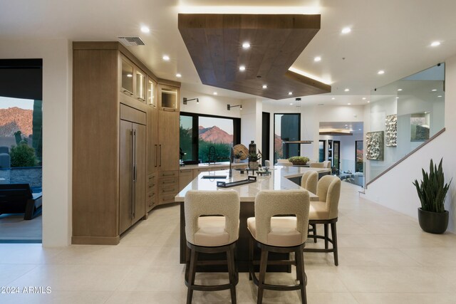 kitchen featuring a breakfast bar, a healthy amount of sunlight, a spacious island, and sink