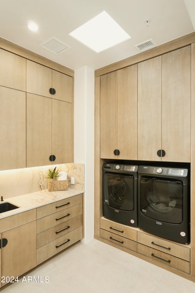 bathroom featuring washing machine and dryer and a skylight