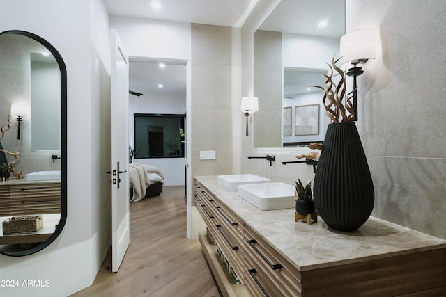 bathroom featuring hardwood / wood-style floors, vanity, and tile walls