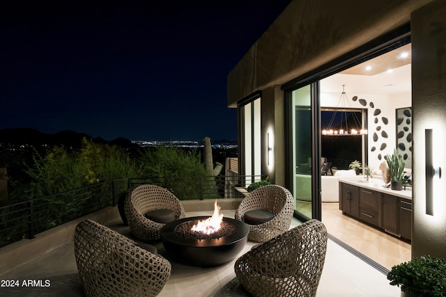 patio at night with sink and an outdoor fire pit