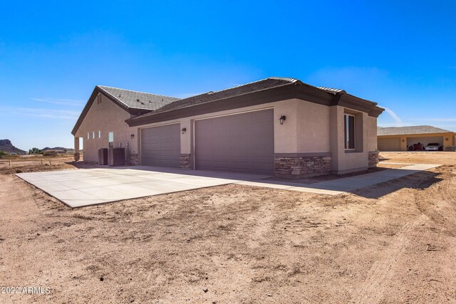 0000 W Hooper Trl Unit 3, Queen Creek, AZ 85144 - view of home's exterior featuring an attached garage, stucco siding, concrete driveway, stone siding, and a tiled roof